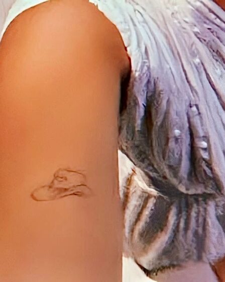 Closeup of Millie Bobby Brown's bicep showing her tiny cowboy hat tattoo.