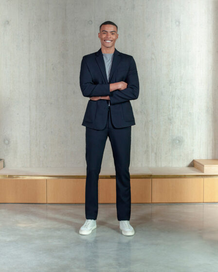 tall man wearing a navy suit and white sneakers