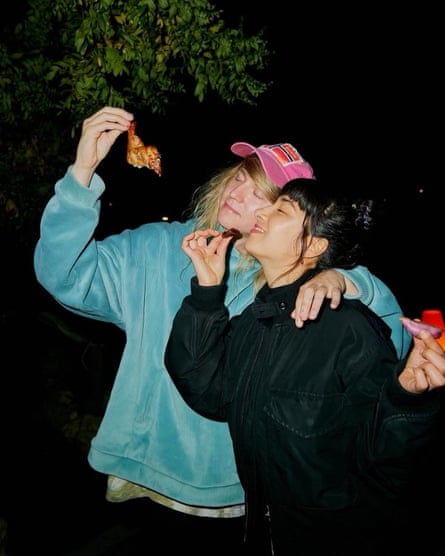 Linda Marigliano and Magnus holding snacks outside at night-time