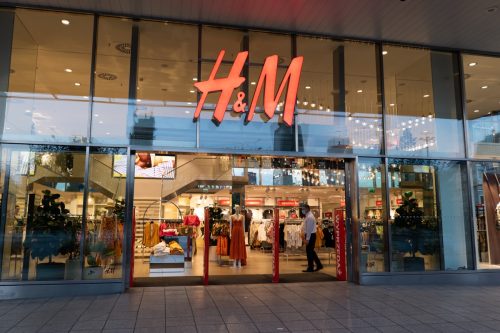 Entrance to H&M store, clothing retail company in the city center at night