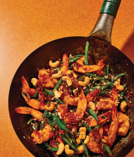 A wok with a stir-fry of sambal prawns with green beans and cashews.