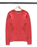 Red cashmere sweater hanging on wooden clothes rack isolated over white