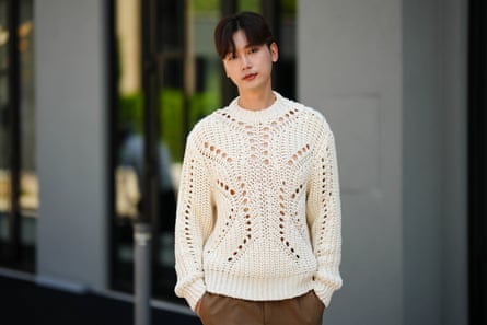 A man wearing a white knitted jumper