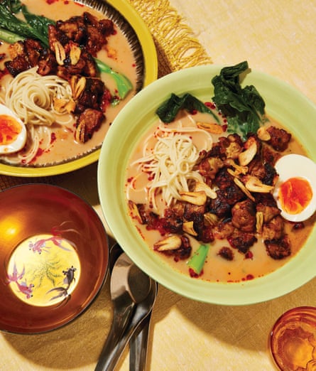 A bowl of noodle soup topped with fried tempeh and a halved boiled egg