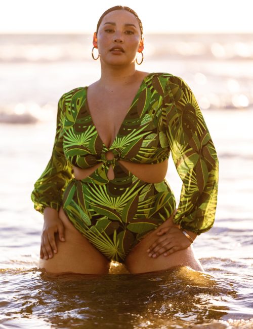 Model wearing a green leaf printed swimsuit for Eloquii