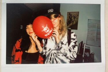 A polaroid of Linda Marigliano and Magnus, who is holding a red balloon with the Triple J radio logo
