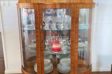 A wooden cabinet filled with crystalware