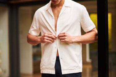 male model buttons his shirt