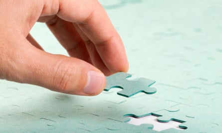 man inserting puzzle piece in puzzle