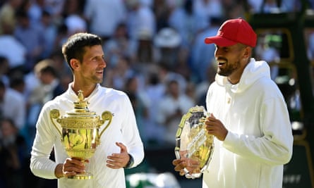 Novak Djokovic and Nick Kyrgios each holding trophies. Kyrgios wears a red baseball cap