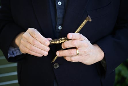 Close-up of a man holding a vintage cast-iron jar opener.