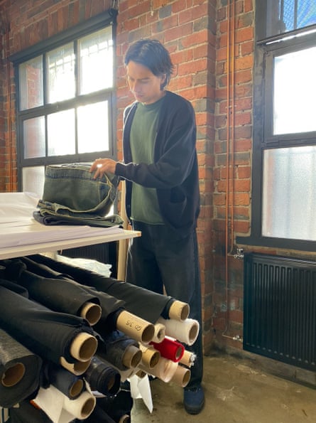 Ivan Budah looking through rolls of denim fabric.