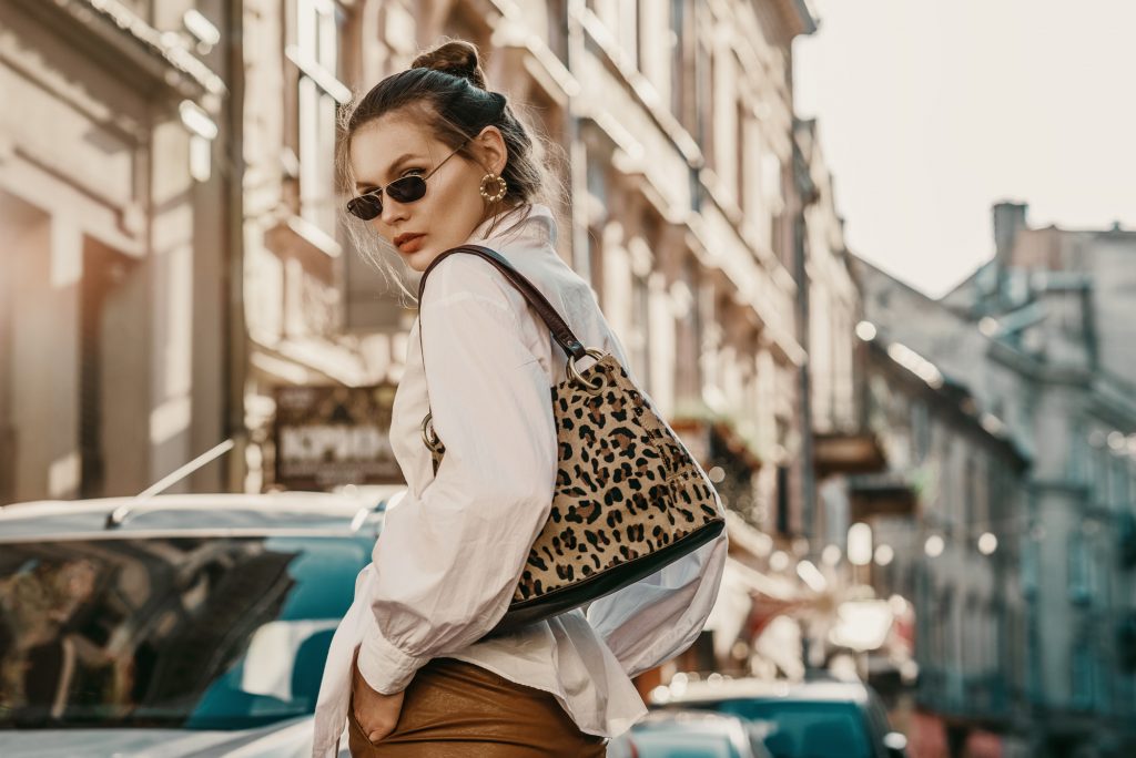 fashionable woman with animal print purse in a city - custom apparel luxury wardrobe