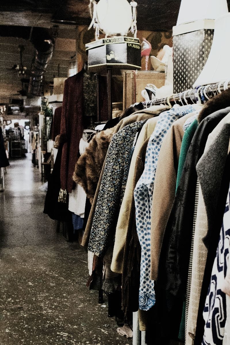 Clothing hanging on rack in thrift store.