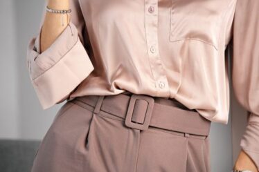 Palazzo trousers with a wide belt and a silk blouse. Powdery pink color. A combination of shades of color in clothing.