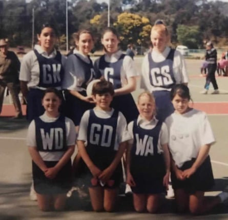 Erin Delahunty and netball teammates pose on a school sports field