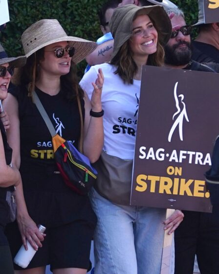 Katie Lowes and Mandy Moore walk the picket line in support of the SAGAFTRA and WGA strike on July 18 2023 in Los...