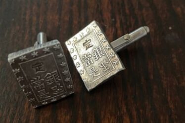 Close-up of a pair of cufflinks made from Japanese Edo-period coins.