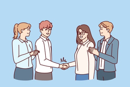 A couple shake hands with people in business attire behind them