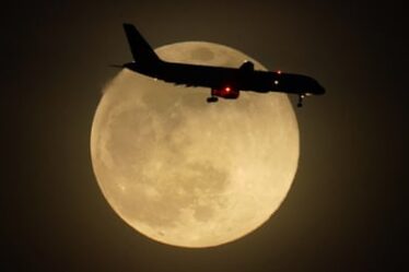 A jet is silhouetted by the rising moon as it approaches Louisville international airport in Kentucky on Monday.