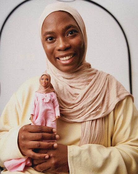 Nigerian artist Haneefah Adam holding one of her Hijarbie creations