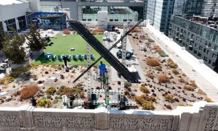 Workers dismantle Twitter’s new X sign mere days after it was installed.