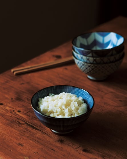 A small blue bowl of rice on a wooden table