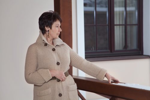 older woman wearing belted sweater coat