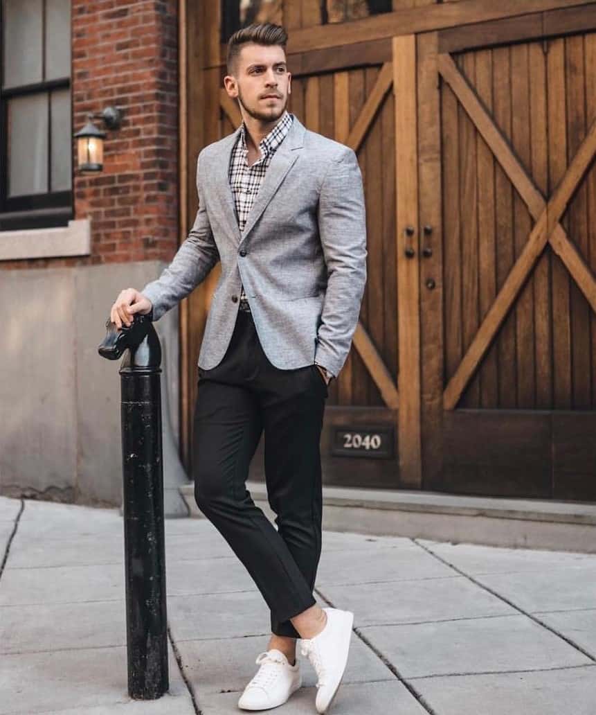 man in a suit standing with legs crossed