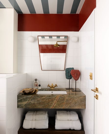 The bathroom’s painted striped ceiling and green marble vanity.