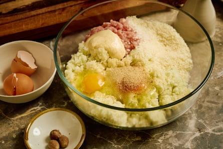 Closeup of a glass bowl containing chicken mince, breadcrumbs, mayonnaise and an egg