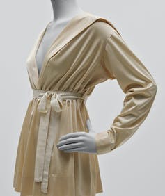 a cream silk blouse with a tie waste.