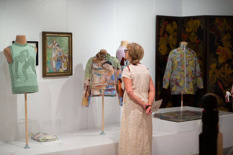 A woman looks at clothes in display case