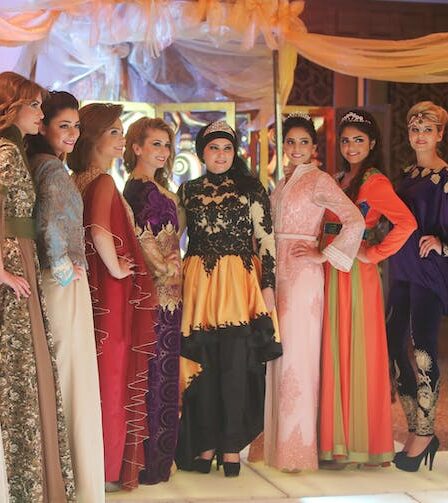 Some women modeling colorful abayas.