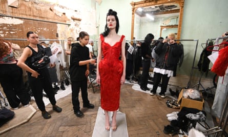 A model in a red dress stands backstage before the Dilara Findikoğlu show during London fashion week 2022