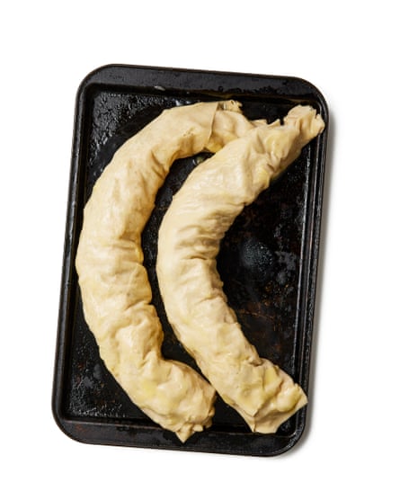 Repeat with the remaining piece of pastry and filling, then gently lift both rolls seam side down on to the greased baking sheet. Curve both into a crescent shape, then brush with melted butter and sprinkle with flaked almonds, if using. Bake for 30-40 minutes, until the pastry is golden and the apples are cooked.