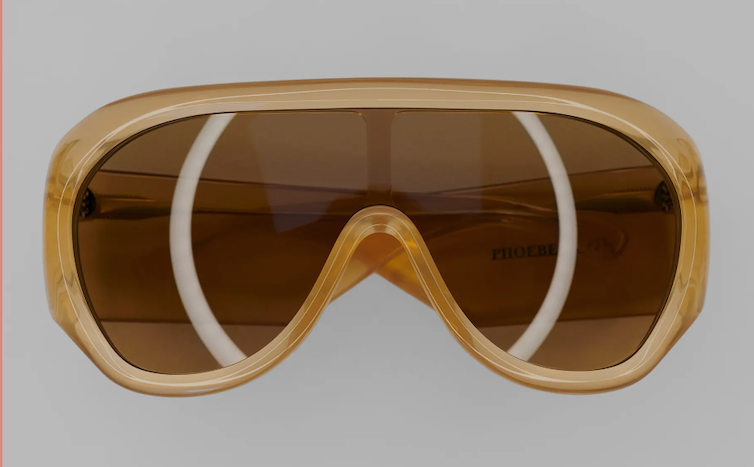 A pair of gold 1970s style sunglasses.