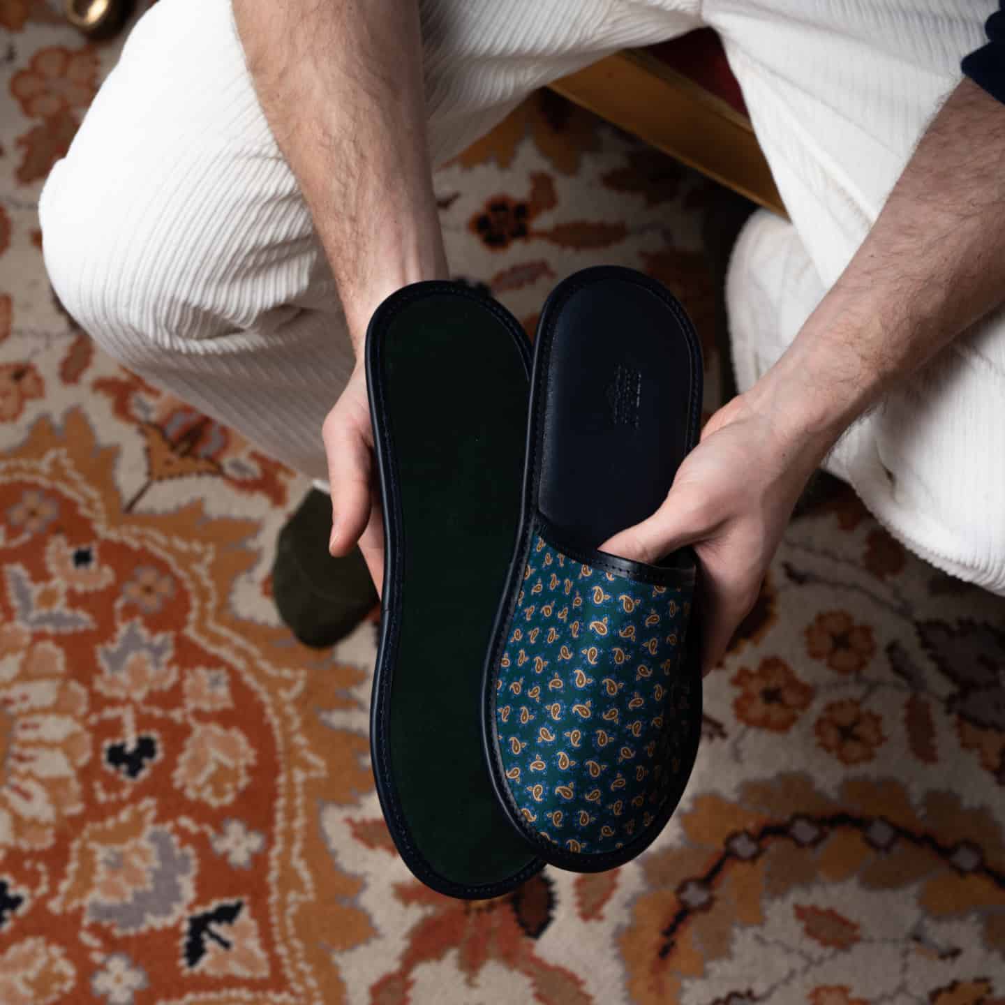 man holding a pair of silk slippers