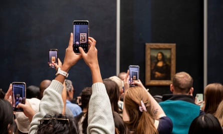 Selfie-snatching … crowds gather around Leonardo’s painting in the Louvre.