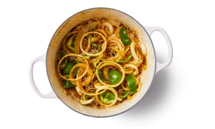 Sliced onion and green pepper cooked in a pot