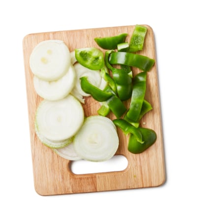 Sliced onions and green peppter on a board