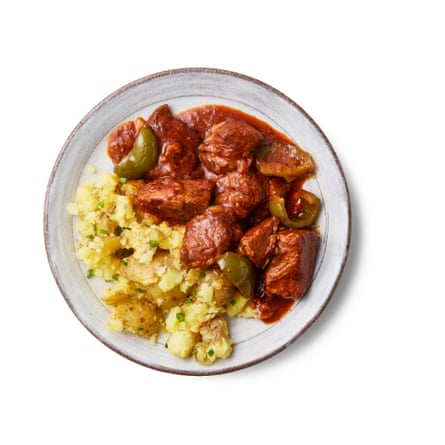 Goulash with green papers next to chopped-up potatoes