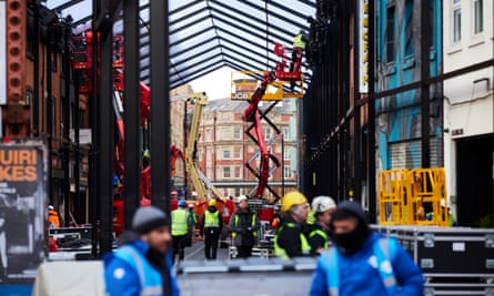 A crane, construction workers, and stewards fill Manchester’s Thomas Street, as the roof is constructed.