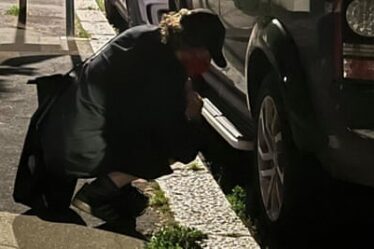 An activist from the Tyre Extinguishers at work in south London lets down an SUV’s tyres on a street at night
