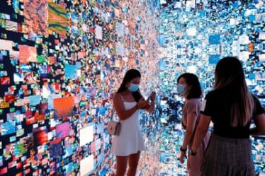 Visitors are pictured in front of an immersive art installation by media artist Refik Anadol, which was converted into NFTs.