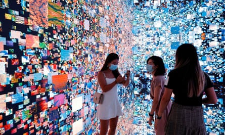 Visitors are pictured in front of an immersive art installation by media artist Refik Anadol, which was converted into NFTs.