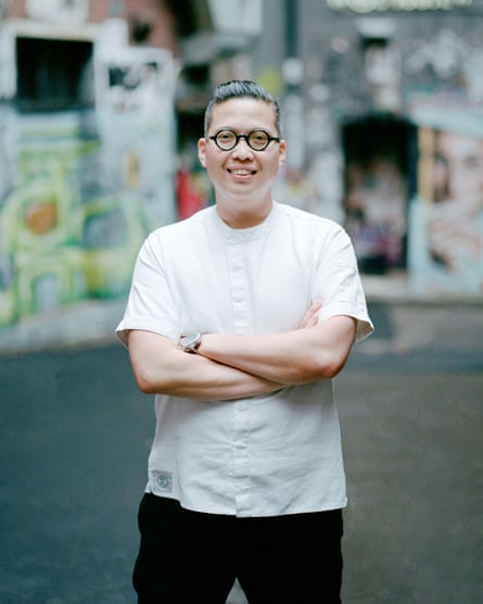 A male chef stands smiling with his arms crossed in a Melbourne laneway.