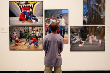 Young man looking at images of sneakers on a gallery wall