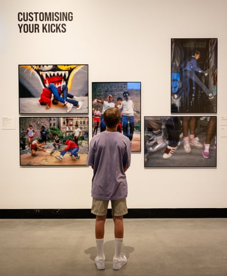 Young man looking at images of sneakers on a gallery wall