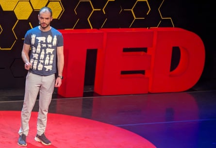 A balding man in front of a Ted prop ion stage.